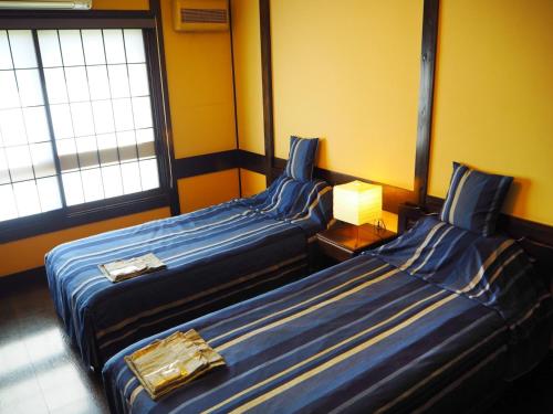 dwa łóżka siedzące obok siebie w pokoju w obiekcie Tamachi Bukeyashiki Hotel - Vacation STAY 20163v w mieście Daisen
