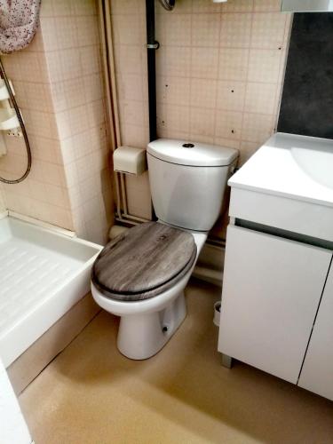 y baño con aseo, bañera y lavamanos. en Appartement, en Lamalou-les-Bains