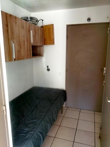 Un dormitorio con una cama verde y una puerta en Appartement, en Lamalou-les-Bains