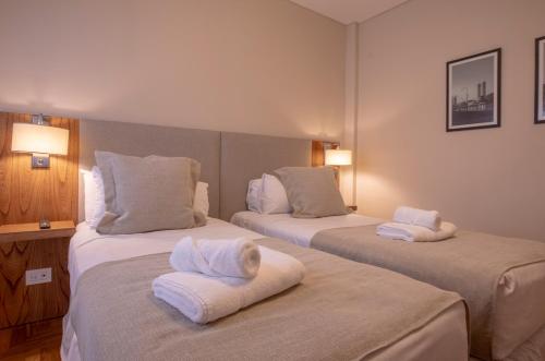 a hotel room with two beds with towels on them at El Misti Coliving Obelisco in Buenos Aires