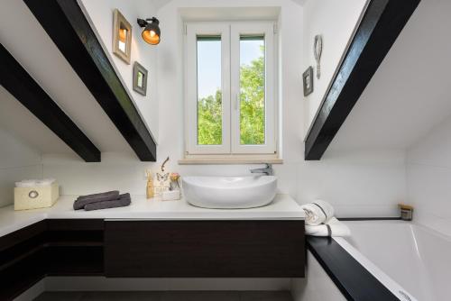 une salle de bain avec un lavabo et une fenêtre dans l'établissement Humac Infinity Vero Apartments, à Donji Humac