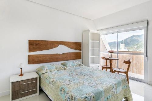 - une chambre avec un lit, une table et une fenêtre dans l'établissement Duplex vista para o mar na praia dos Açores, à Florianópolis