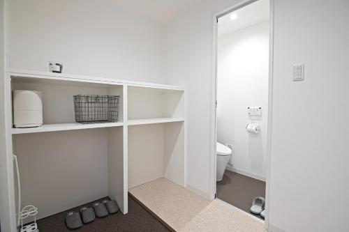 bagno bianco con servizi igienici e porta in vetro. di KyotoGosyonishi - Vacation STAY 23016v a Kyoto