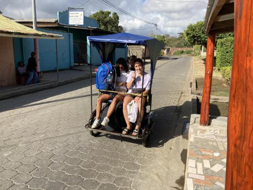 a group of three people riding on a cart at Hostel Julieta in Rivas