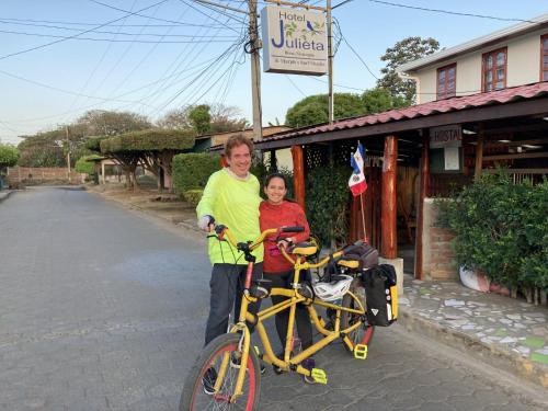 a man and a woman standing next to a bike at Hostel Julieta in Rivas