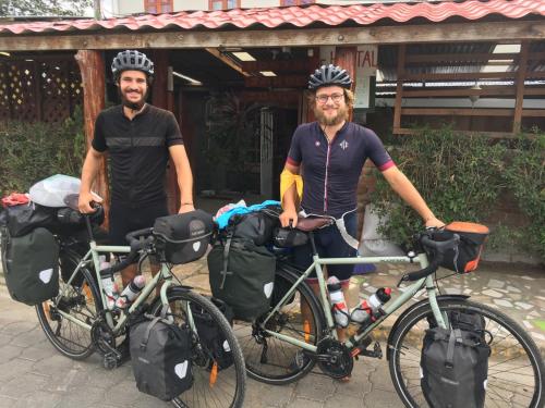 two men wearing helmets standing next to their bikes at Hostel Julieta in Rivas