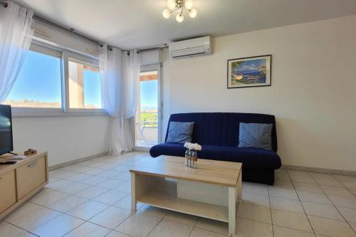 uma sala de estar com um sofá azul e uma mesa de centro em Lovely spacious nest in Port Fréjus em Fréjus