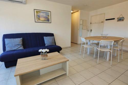 un salon avec un canapé bleu et une table dans l'établissement Lovely spacious nest in Port Fréjus, à Fréjus