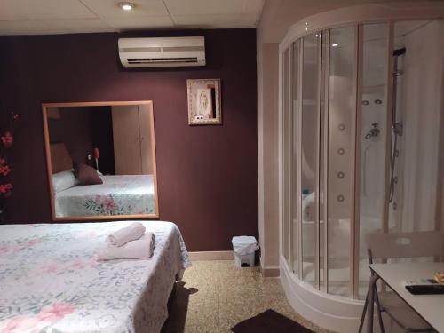 a bedroom with a shower and a bed and a mirror at Hostal Happystay in Valencia