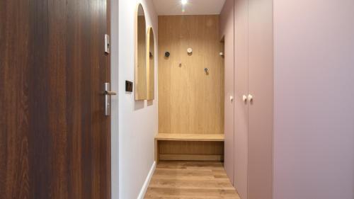 a hallway with a closet with a wooden door at Apartament By Miło Było in Ustroń