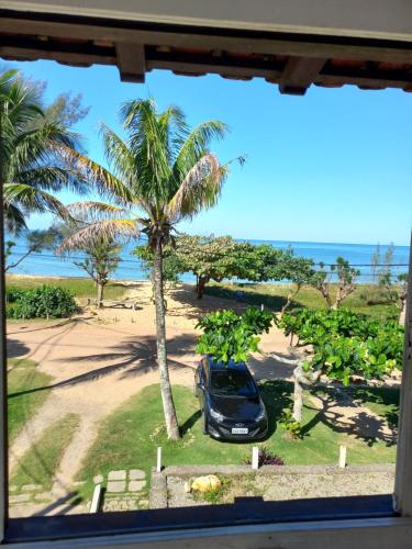 a car parked in front of a palm tree at Pousada da Barra in Barra de São João