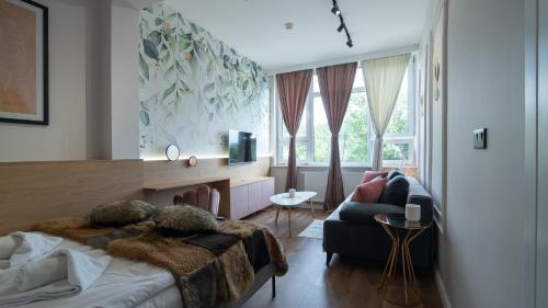 a bedroom with a bed and a couch at Apartament By Miło Było in Ustroń