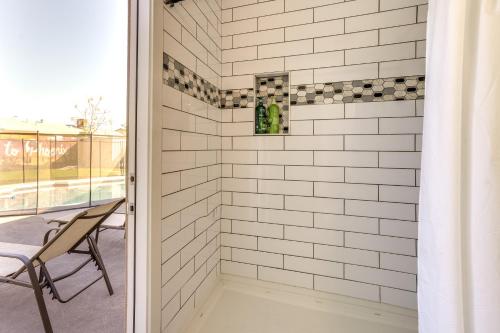 ducha de azulejos blancos con silla y ventana en Phoenix Oasis with Outdoor Pool and Putting Green! en Phoenix