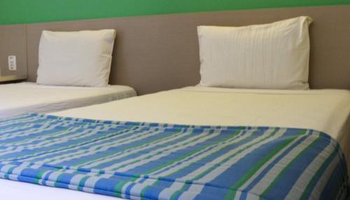 two beds sitting next to each other in a room at Go Inn Hotel Aracaju in Aracaju