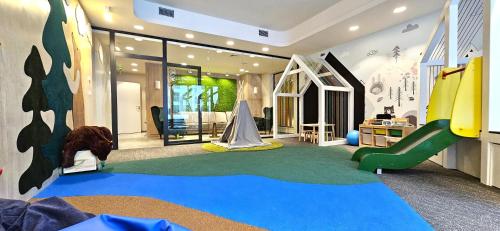 una sala giochi per bambini con scivolo e parco giochi di VIP Apartamenty Zakopianskie a Zakopane