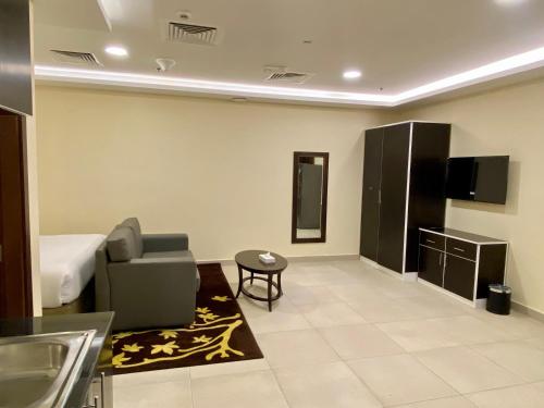 a room with a bed and a couch and a tv at City Stay Residences - Serviced Apartments DIP in Dubai