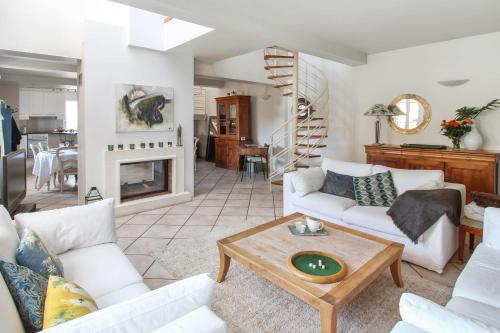 a living room with white furniture and a fireplace at Charming house with garden in Sèvres - Welkeys in Sèvres