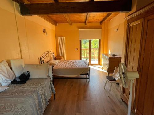 a bedroom with a bed and a dresser and a window at Adagio Guesthouse in Caprie