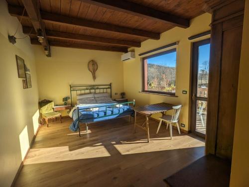 Caprie的住宿－Adagio Guesthouse，一间卧室配有一张床、一张桌子和一个窗户。