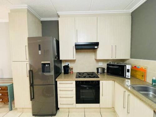 a kitchen with white cabinets and a stainless steel refrigerator at 361 On Sunset in Sandton