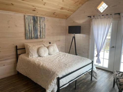 een slaapkamer met een bed in een kamer met houten wanden bij Cottage Core Farmstay @ the TINY HOME in Trenton