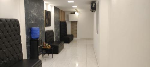 a hallway with black chairs and a white tile floor at Hotel Mykonos Manta in Manta