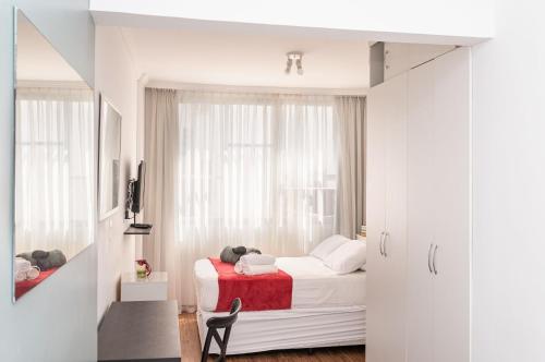 een witte slaapkamer met een bed en een raam bij Sunset Urca - 2 Hóspedes, Conforto e lazer in Rio de Janeiro