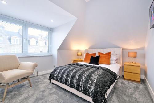 a bedroom with a bed and a chair and a window at The Northern House in Aberdeen