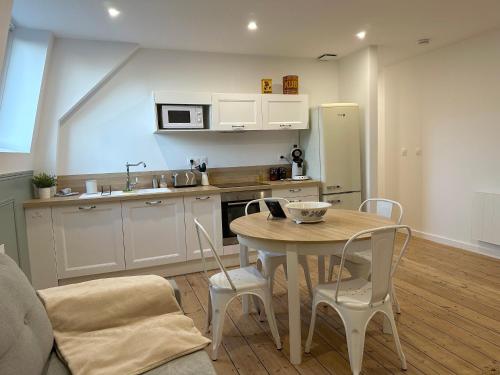 a kitchen with a table and chairs and a kitchen with a refrigerator at ღ Fabrik • Parking sécurisé & Wifi fibre in Douai