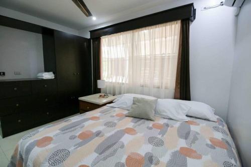 a bedroom with a large bed with a window at Casa Alma in Liberia