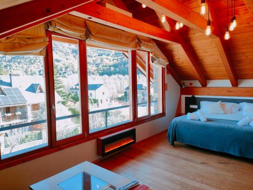 a bedroom with a bed in a room with windows at Can Congost in Sort