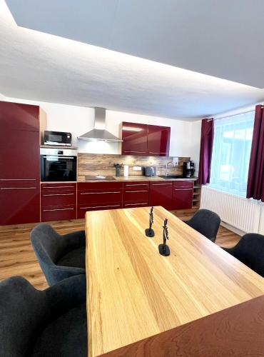 a kitchen with a wooden table in a room at Ferienhaus Zum Lochstein - FW Gesindehaus in Sankt Andreasberg