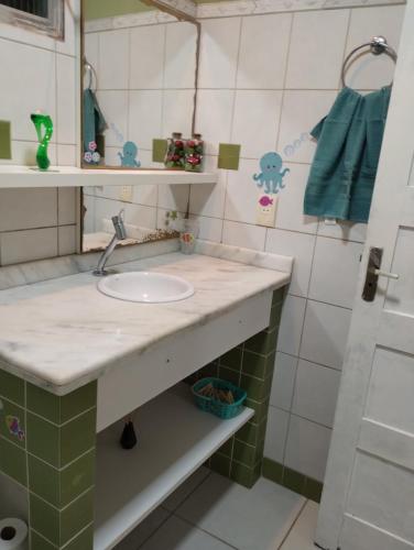 a bathroom with a sink and a mirror at Apartamento na Praia in Torres