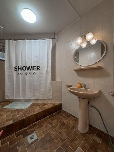 a bathroom with a shower curtain and a sink at Omega Apartman in Miskolc