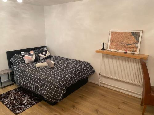 a bedroom with a bed with a black and white blanket at 2 bedroom flat Camberwell grove in London