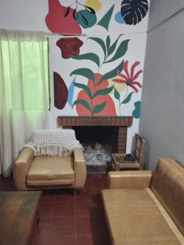 a living room with a fireplace and a colorful wall at CASA EN TAFI DEL VALLE ZONA LA ANGOSTURA in San Miguel de Tucumán