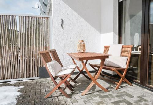 een houten tafel en stoelen op een patio bij MILANA Naturpanorma, ruhig & familienfreundlich in Winterberg