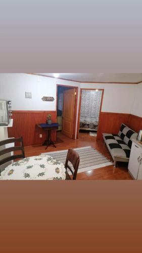 sala de estar con sofá, mesa y sillas en Apartamento 410 en Punta Arenas