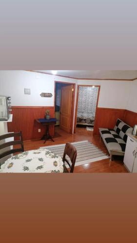 a living room with a couch and a table and chairs at Apartamento 410 in Punta Arenas