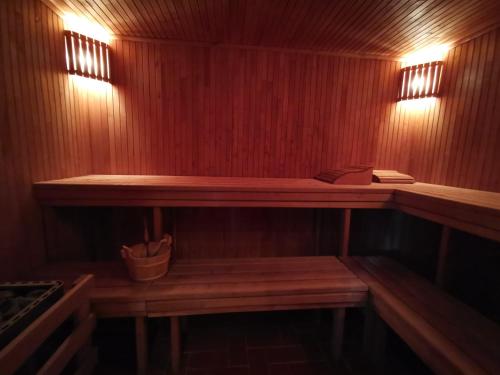 a sauna with a wooden bench and lights on the wall at Flip-Flops Apartment Jurmala with free parking in Jūrmala