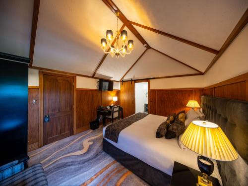 a hotel room with a bed and a chandelier at Hana Lodge in Rotorua