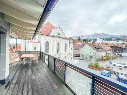 een balkon met uitzicht op een kerk bij Sunset Club - Nesselwang Chalets Nr 1 in Nesselwang