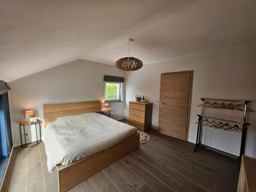 a bedroom with a large white bed and a window at Les Secrets du Bois in Vielsalm