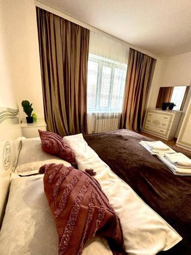 ein Schlafzimmer mit einem großen Bett mit Kissen darauf in der Unterkunft ЖК Трилистник in Qaraghandy