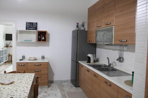una cucina con lavandino e frigorifero di b&b Brupier a Ruvo di Puglia