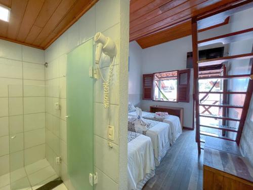 a room with two beds and a shower in it at Pousada do Norte in Jericoacoara