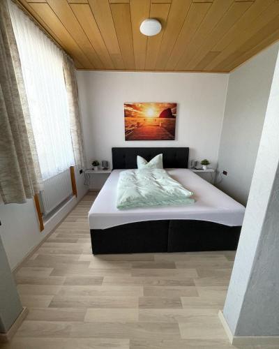 a bedroom with a bed with a painting on the wall at Rheinhotel Kelch in Weißenthurm