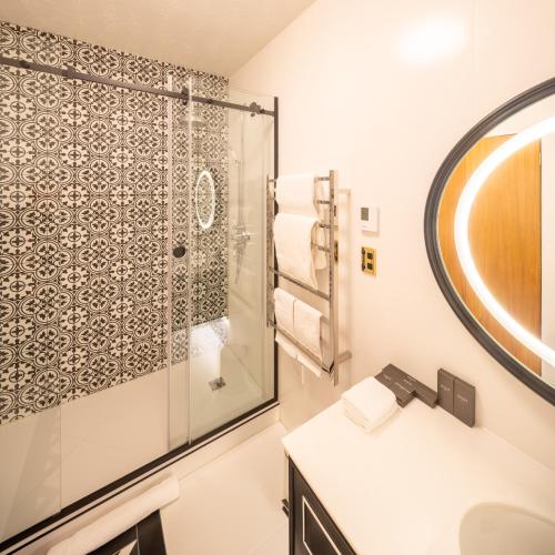 a bathroom with a shower and a sink at Hana Lodge in Rotorua