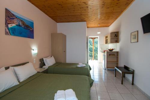 una camera d'albergo con due letti e una cucina di Villa Levante a Vasilikós