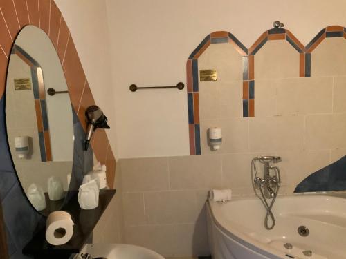 a bathroom with a tub and a sink and a mirror at Hotel y Apartamentos Penarronda Playa in Castropol